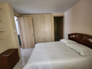 - une chambre avec un lit et une porte menant à une pièce dans l'établissement Apartamento completo en el sur de Buga, à Buga