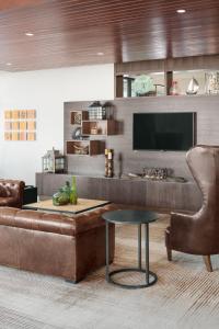 a living room with a couch and a table and a tv at Courtyard by Marriott Portland Downtown/Waterfront in Portland