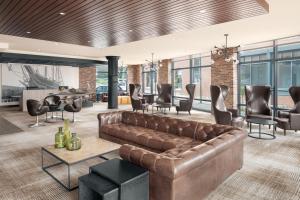 a living room with a brown leather couch and chairs at Courtyard by Marriott Portland Downtown/Waterfront in Portland