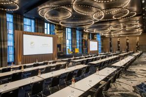 une grande chambre avec des tables et des chaises et un écran de projection dans l'établissement Element Philadelphia Downtown, à Philadelphie