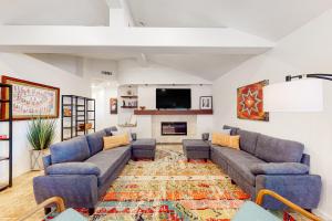 a living room with couches and a tv at Piestewa Getaway in Phoenix