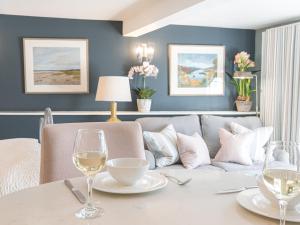 a dining room with a couch and a table with wine glasses at Prospect Cottage Studio in Ambleside
