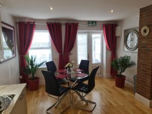 een eetkamer met rode gordijnen en een tafel en stoelen bij Dunderry Lodge Self Catering Family Lodges in Navan