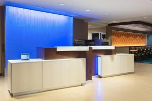 een lobby met een blauwe muur en tafels en stoelen bij Fairfield Inn & Suites by Marriott Belle Vernon in Belle Vernon