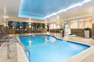 a pool in a hotel lobby with chairs and tables at Fairfield Inn & Suites by Marriott Belle Vernon in Belle Vernon