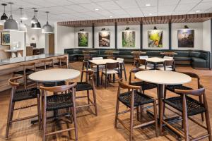 a restaurant with tables and chairs and a bar at Fairfield by Marriott Inn & Suites Duluth in Duluth
