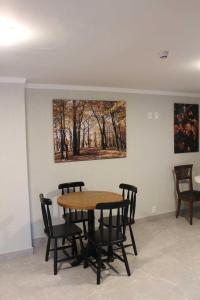 a table and chairs in a room with a painting on the wall at Hotel San Lucas in Gramado