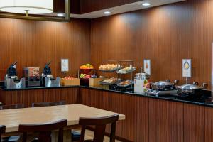 a restaurant with a table and a counter with food at Fairfield Inn & Suites Detroit Farmington Hills in Farmington Hills