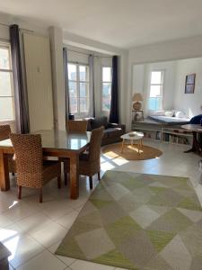 een woonkamer met een tafel en stoelen en een bank bij Les catalans, vue mer in Marseille