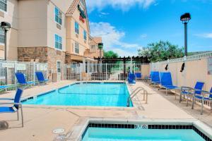 uma piscina com cadeiras e um edifício em TownePlace Suites by Marriott Las Cruces em Las Cruces