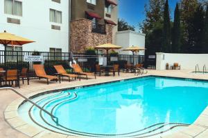 a swimming pool at a hotel with chairs and umbrellas at Courtyard by Marriott Paso Robles in Paso Robles