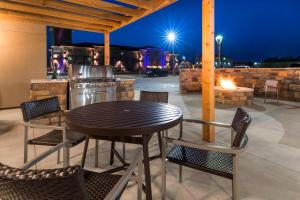 Towneplace Suites By Marriott Hays في هيز: طاولة وكراسي على الفناء في الليل