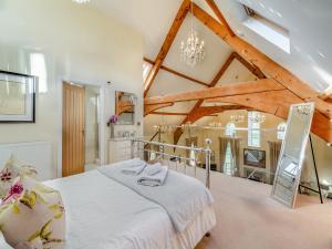 a bedroom with a large bed in a room with wooden ceilings at The Old Chapel in Spark Bridge