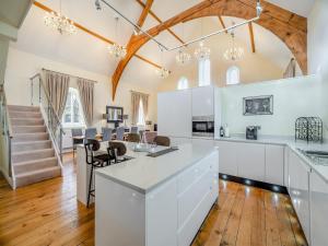 a kitchen with white cabinets and a dining room at The Old Chapel in Spark Bridge