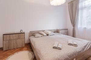 a bedroom with a bed with two slippers on it at Lovely Art apartment - Victory in Varna City