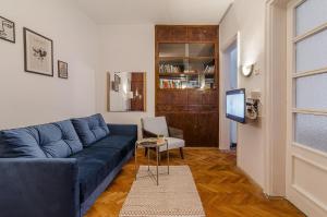 a living room with a blue couch and a tv at Lovely Art apartment - Victory in Varna City