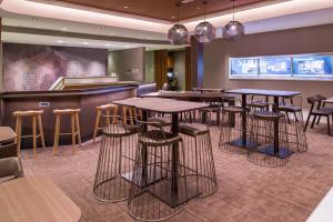 a bar with tables and stools in a restaurant at SpringHill Suites by Marriott Greensboro Airport in Friendship