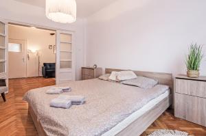 a bedroom with a large bed with towels on it at Lovely Art apartment - Victory in Varna City
