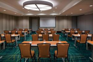 a conference room with tables and chairs and a screen at SpringHill Suites by Marriott Houston Downtown/Convention Center in Houston