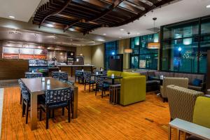 a restaurant with tables and chairs and a bar at Courtyard by Marriott Little Rock Downtown in Little Rock