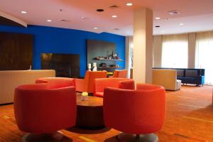 una sala d'attesa con tavolo e sedie arancioni di Courtyard Blacksburg a Blacksburg