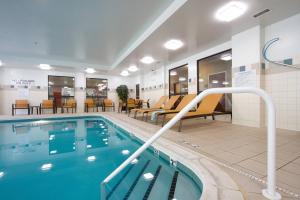 una piscina in un hotel con sedie e tavoli di Courtyard Blacksburg a Blacksburg
