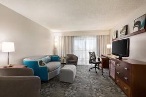 a hotel room with a couch and a tv at Courtyard Lubbock in Lubbock
