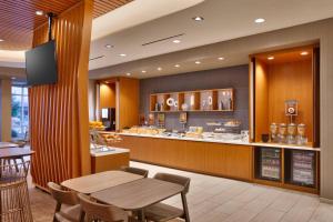 a restaurant with a table and a food counter at SpringHill Suites by Marriott Salt Lake City-South Jordan in South Jordan