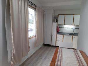 uma pequena cozinha com uma janela e uma mesa em Monseñor Fagnano 592 "5" em Ushuaia