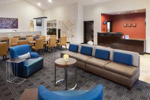 a lobby with a couch and tables and chairs at TownePlace Suites by Marriott San Antonio Airport in San Antonio