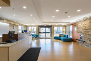 een kantoorlobby met een blauwe bank en een open haard bij Fairfield Inn Manchester - Boston Regional Airport in Manchester