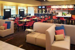 a restaurant with tables and chairs and a bar at Courtyard by Marriott Lexington North in Lexington