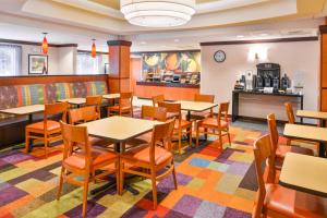 a restaurant with tables and chairs and a counter at Fairfield Inn and Suites by Marriott Asheboro in Asheboro