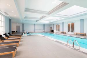 a large swimming pool with benches and a swimming pool at Mystic Marriott Hotel and Spa in Groton