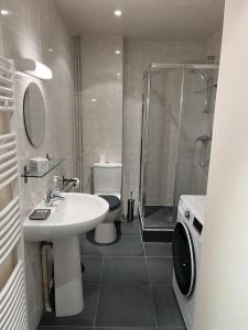 La salle de bains est pourvue d'un lavabo, d'une douche et de toilettes. dans l'établissement Les Bains de Trouville, à Trouville-sur-Mer
