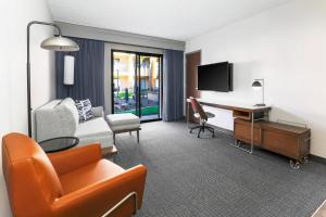 a hotel room with a couch and a desk at Courtyard Tucson Airport in Tucson