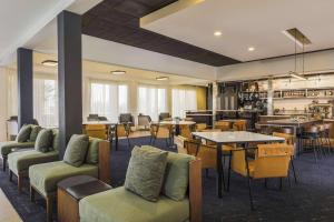 a hotel lobby with tables and chairs and a restaurant at Courtyard Tucson Airport in Tucson