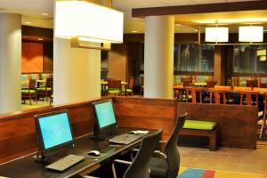 a lobby with two computers on a table with chairs at Fairfield Inn & Suites by Marriott Omaha Northwest in Omaha