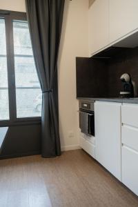 a kitchen with a black curtain and a window at Studio Ropartz au pied du métro in Rennes