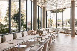 hol z kanapami i stołami oraz dużymi oknami w obiekcie AC Hotel by Marriott Sunnyvale Moffett Park w mieście Sunnyvale