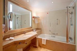 a bathroom with a tub and a sink and a shower at Praia D'El Rey Marriott Golf & Beach Resort in Casal da Lagoa Seca