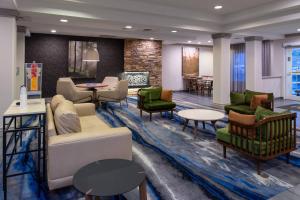 a living room with couches and chairs and tables at Fairfield Inn & Suites High Point Archdale in Archdale