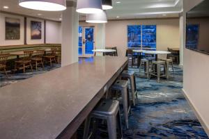 a large counter in a room with tables and stools at Fairfield Inn & Suites High Point Archdale in Archdale