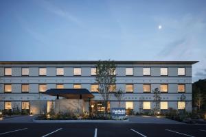 un edificio con un estacionamiento delante de él en Fairfield by Marriott Hyogo Kannabe Highland en Toyooka