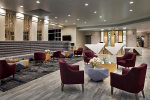 a lobby of a hotel with chairs and tables at Sheraton Richmond Airport Hotel in Sandston