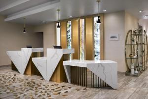un vestíbulo con dos escritorios blancos de recepción en un edificio en Sheraton Richmond Airport Hotel en Sandston