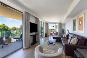 a living room with a couch and a tv at Hotel Citrine, Palo Alto, a Tribute Portfolio Hotel in Palo Alto