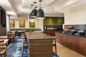 a kitchen with wooden cabinets and a bar with chairs at Fairfield Inn & Suites Findlay in Findlay