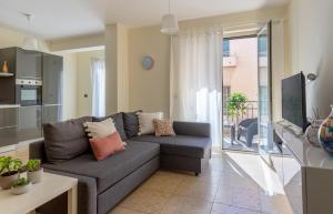 a living room with a gray couch and a balcony at relax apartment inn in Catania