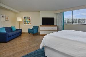 a hotel room with a bed and a tv and a couch at Sheraton Orlando Lake Buena Vista Resort in Orlando